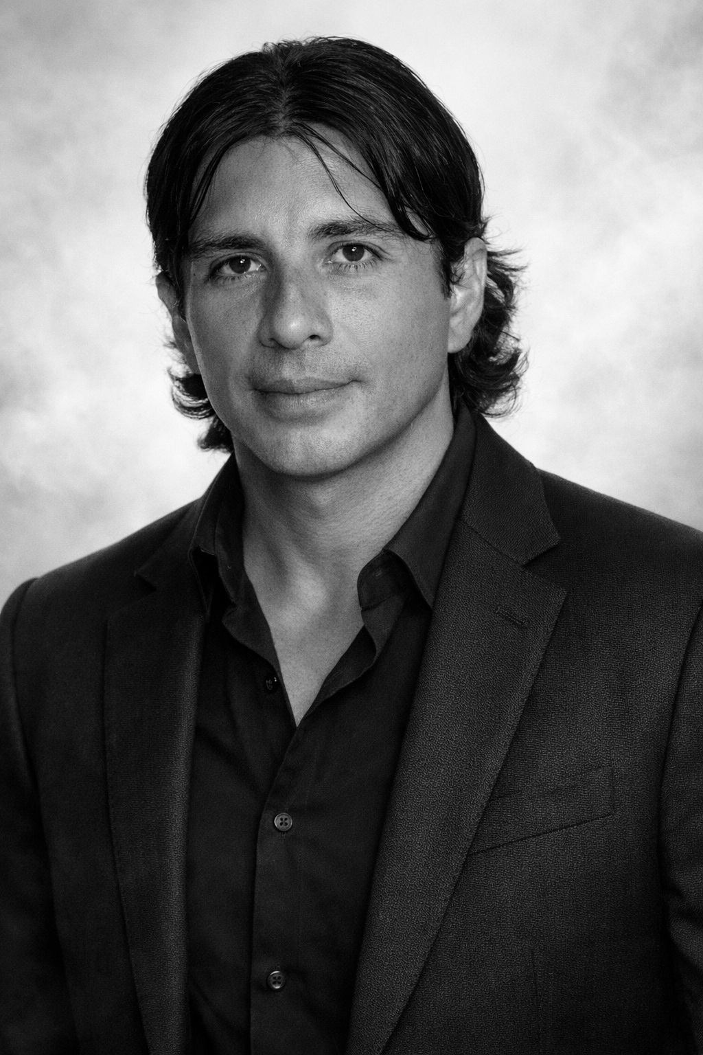 Professional portrait of a man in a suit standing in an office